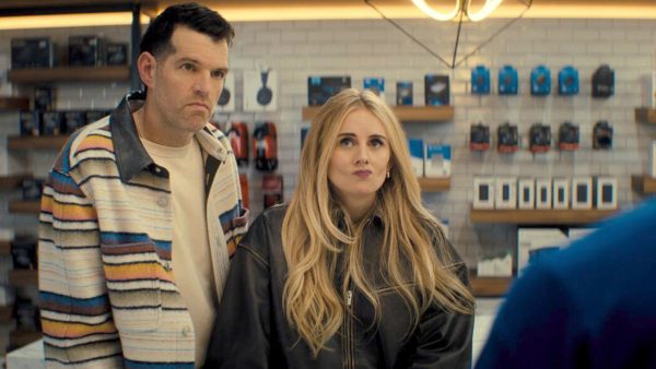 Timothy Simons (Sasha) & Justine Lupe (Morgan) from Netflix’s ‘Nobody Wants This’ stand in a store during a scene from the series.